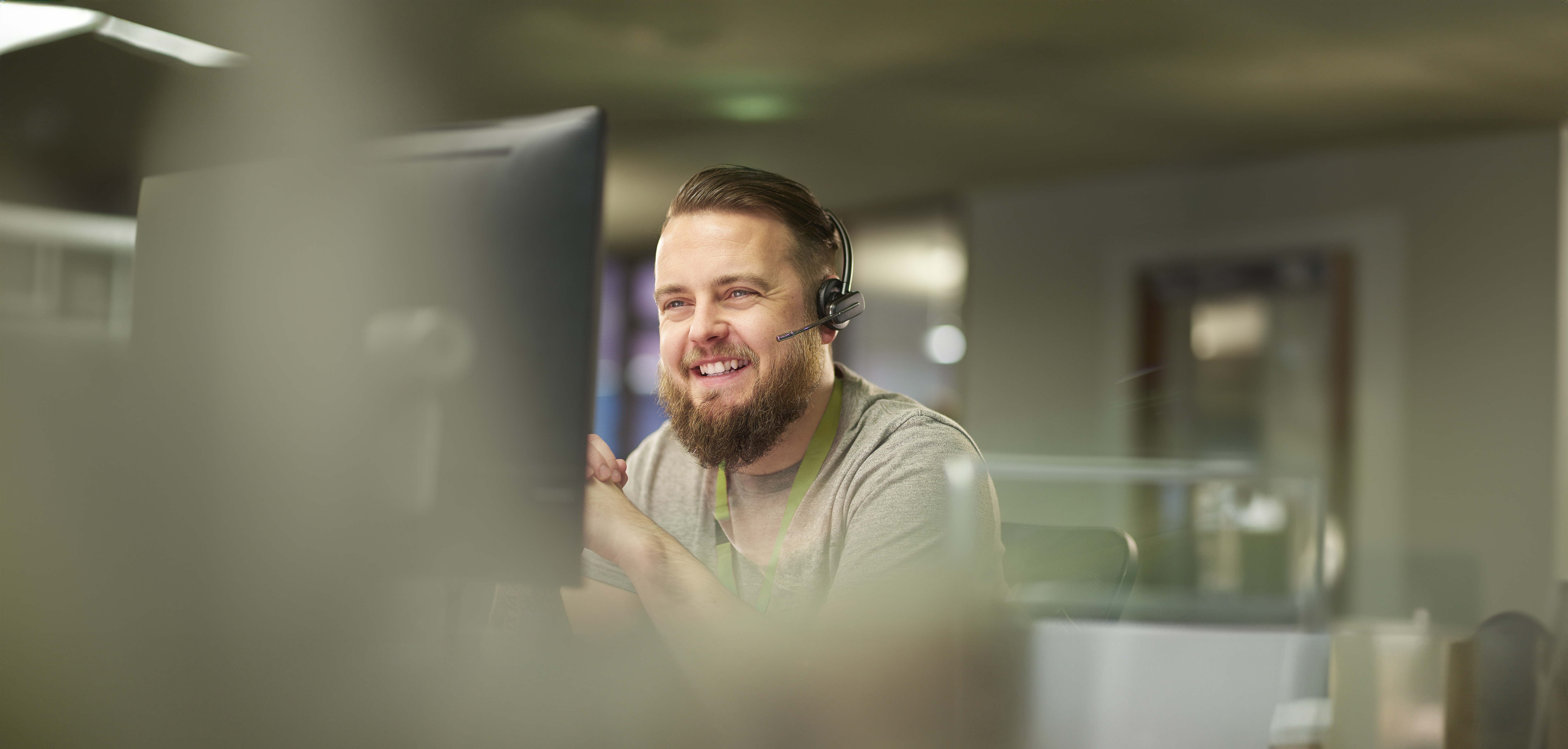 IT reseller with headset sitting in front of a monitor